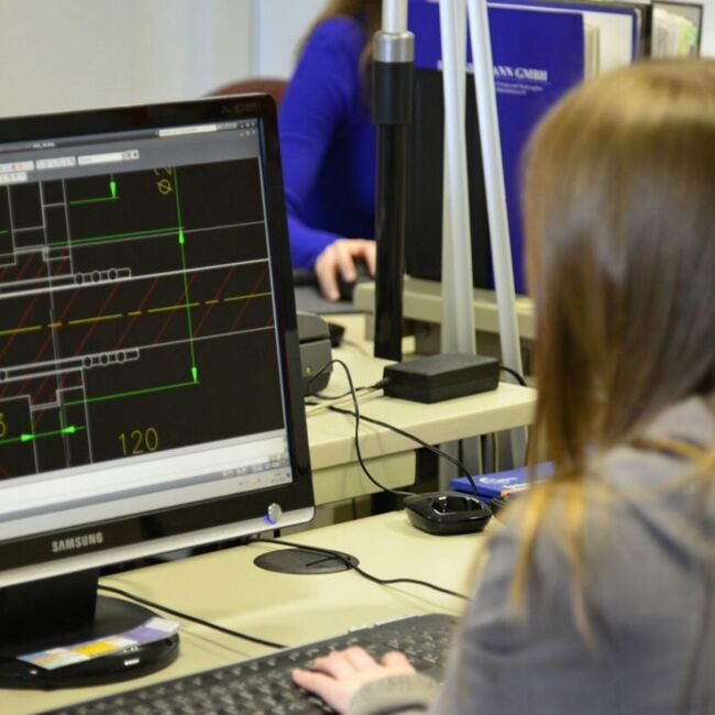 Ein Mann sitzt vor dem PC und entwirft ein Werkstück