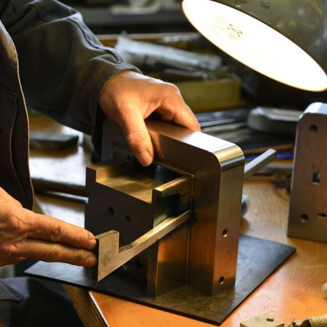 Ein Mann bearbeitet ein Werkstück an einer Werkbank